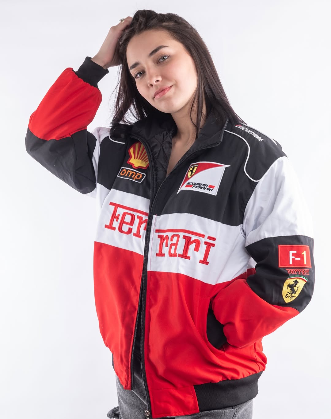 Woman wearing a Ferrari racing jacket with logos on a white background