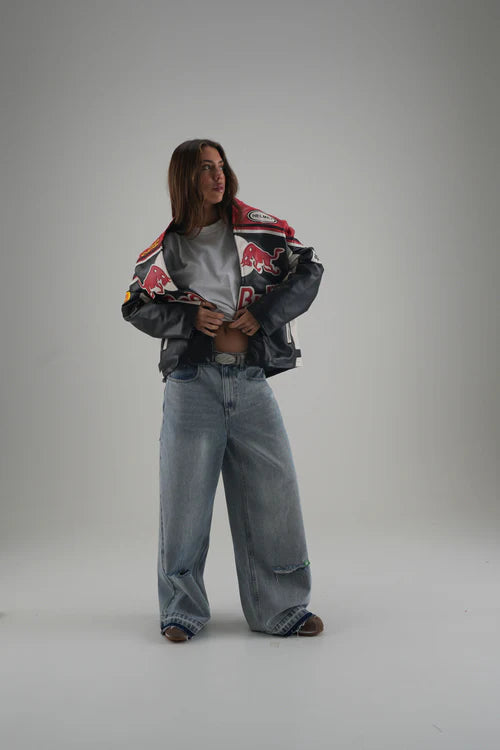 Women Model Wearing Red Bull faux leather vintage jacket by LZRUS with retro motorsport-inspired design in black, red, and white.