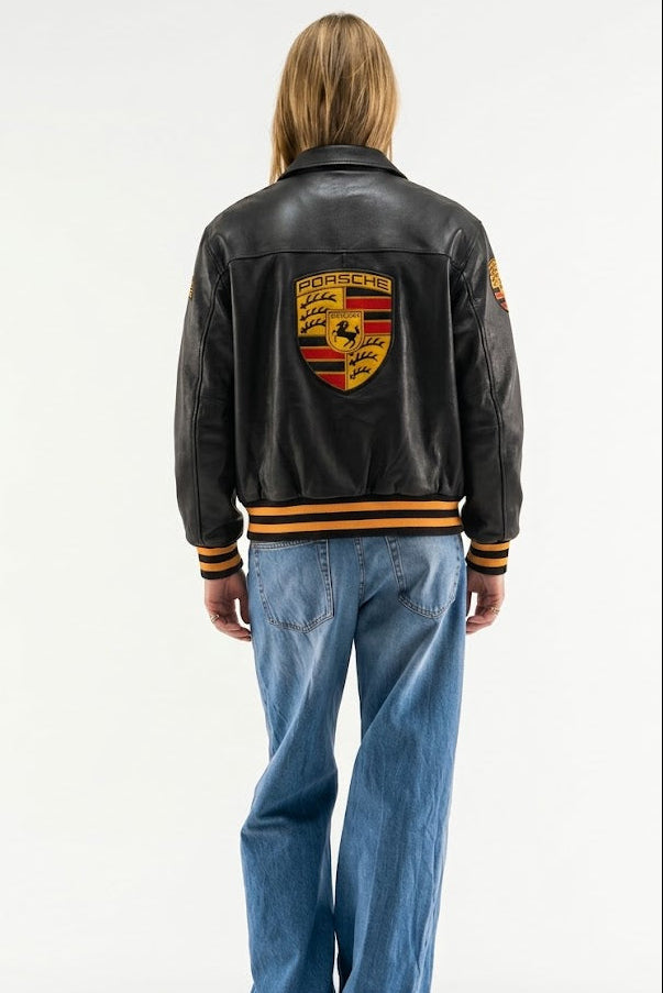 Black Porsche bomber jacket rear view showing gold striped cuffs and hem, unisex fit – LZRUS