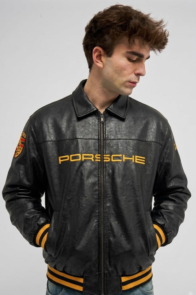Black Porsche leather jacket front view with gold chest wordmark and striped ribbed hem – LZRUS