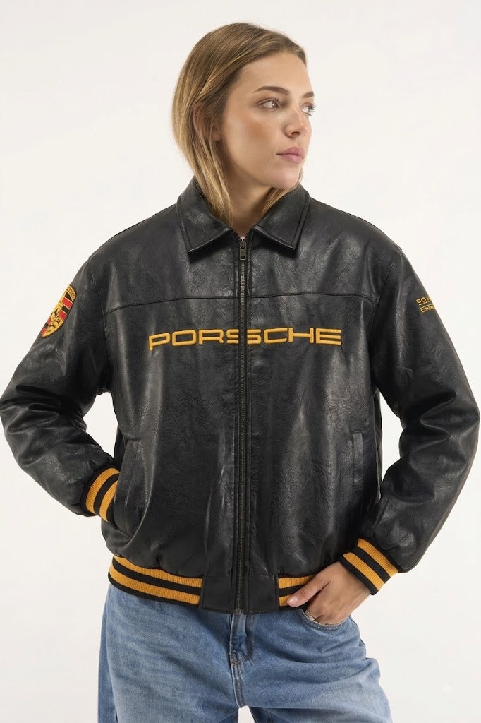 Woman wearing black Porsche leather bomber jacket with gold embroidery and blue jeans – LZRUS