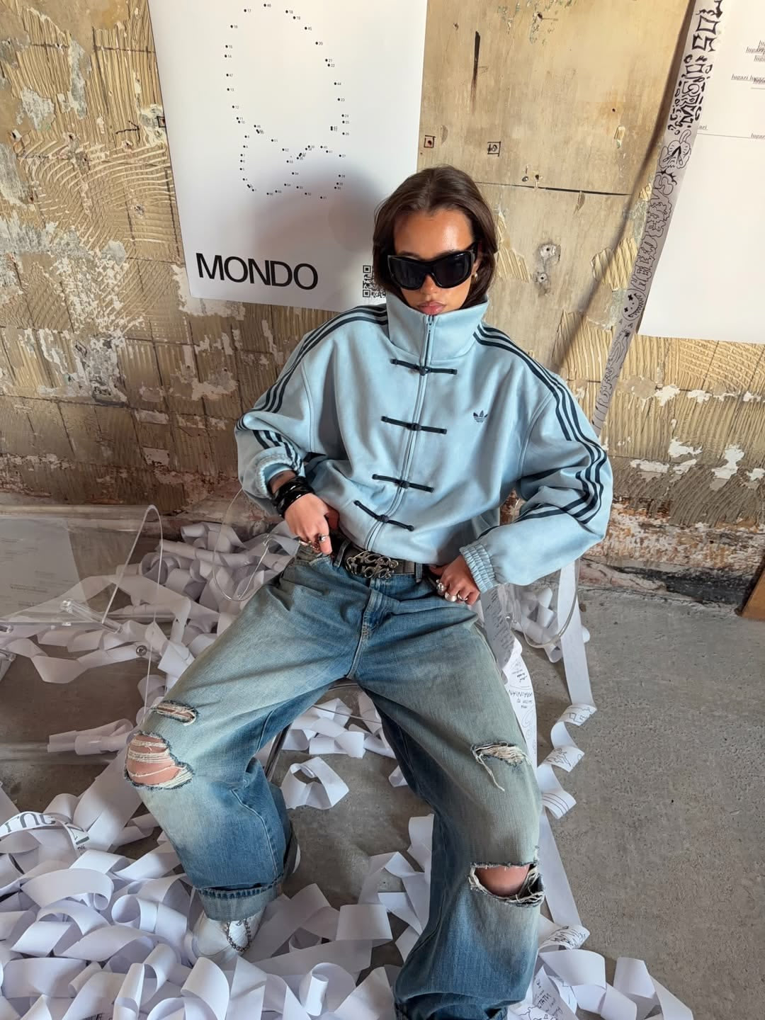 Adidas-inspired sky blue tang jacket styled with distressed baggy jeans and sunglasses for an oversized streetwear look